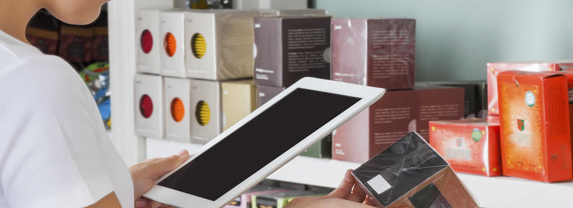 Shop manager scanning a product and sending orders back to supplier for new supplies on a tablet